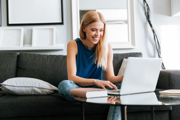 A woman laughing on her laptop.