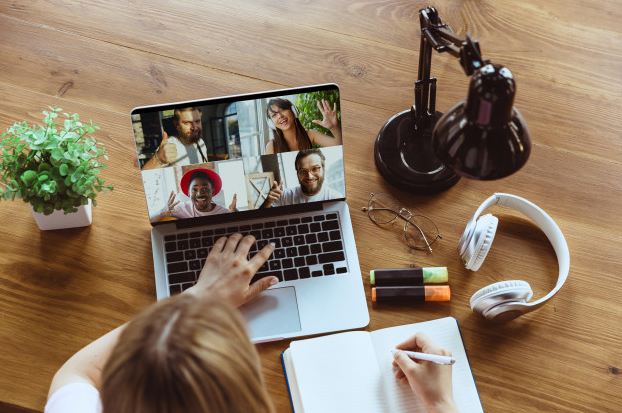 A woman on an online video call with four attendees in times of COVID.