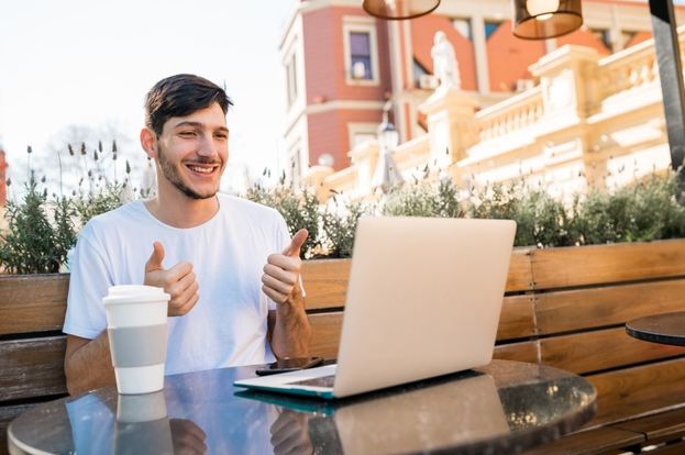 An image of a man delivering a speech online using his laptop.