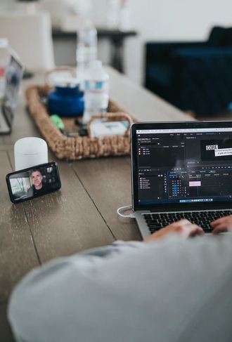 An image of an online meeting on the phone and a laptop