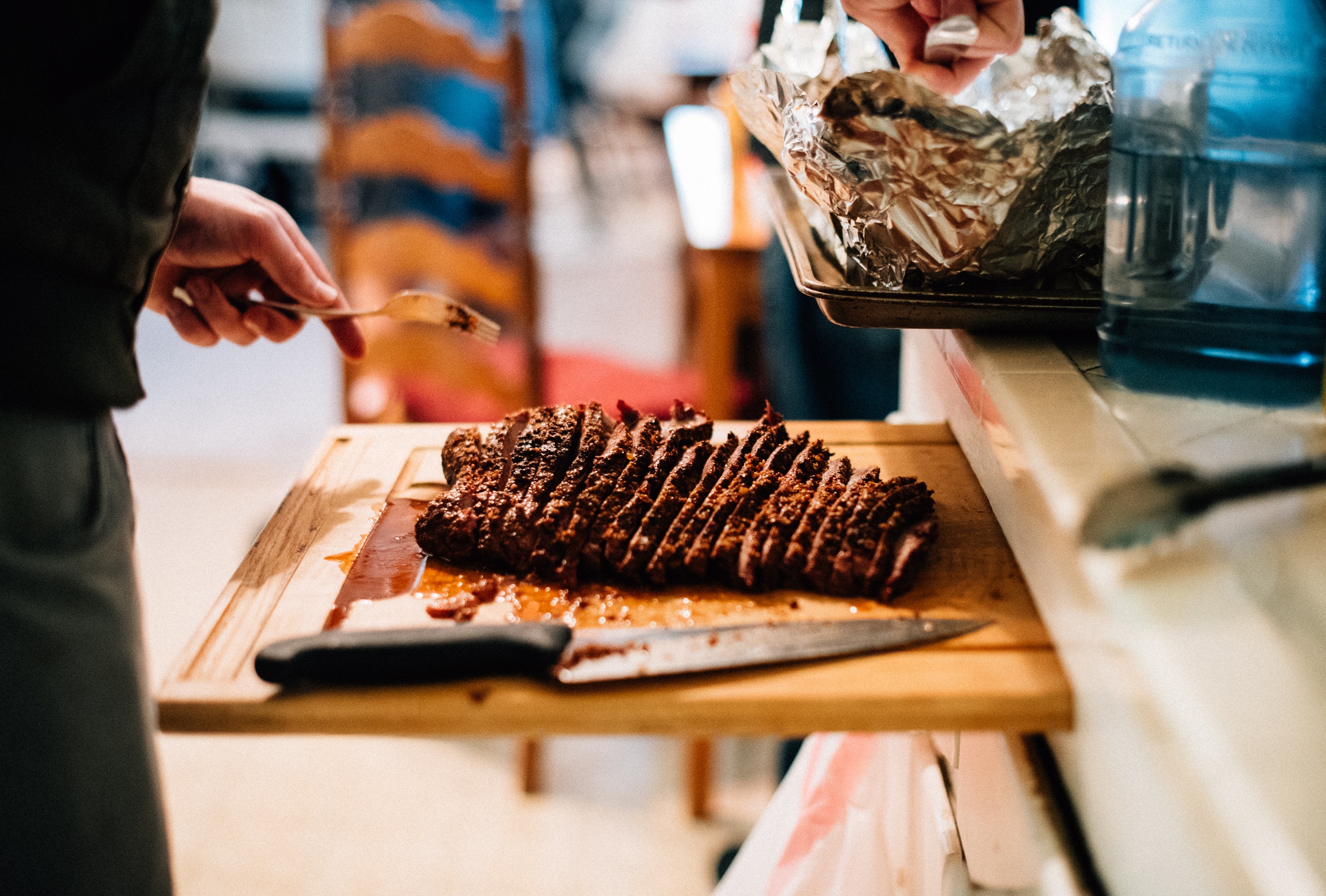 the person holding knife slicing meat