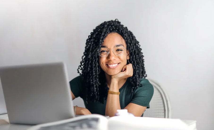 An image of a happy ethnic woman with her laptop on a table