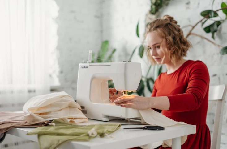 A woman Sewing While Sitting On Chair