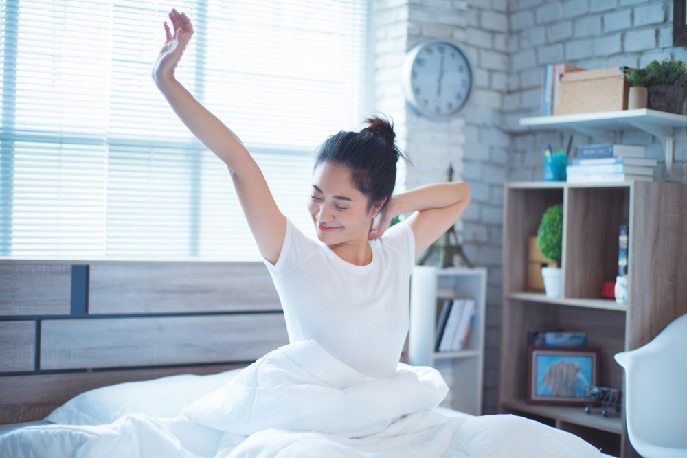 Shot of a multi-tasking young business woman talking on her smartphone and drinking coffee in her kitchen while getting ready to go to work