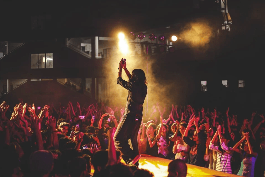 silhouette of a man having a concert on a stage with audiences