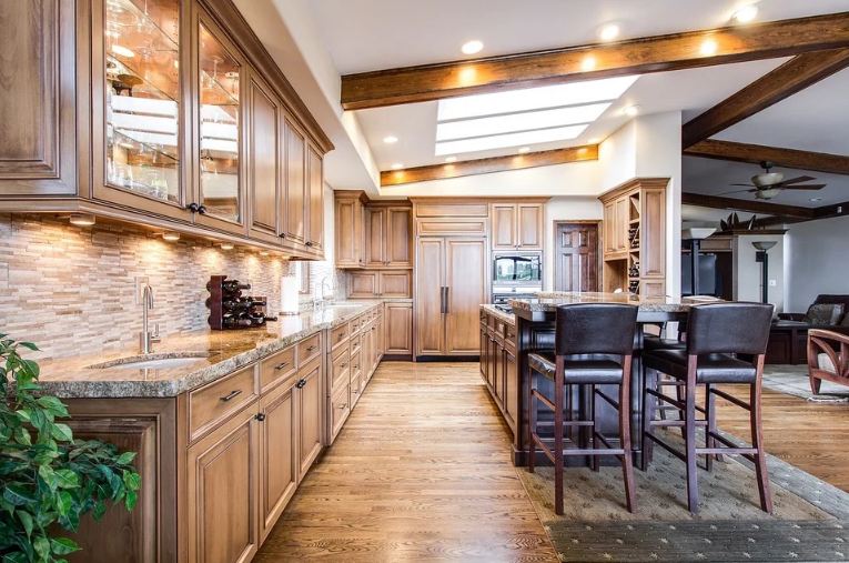 a kitchen with lots of cabinets and two chairs for sitting