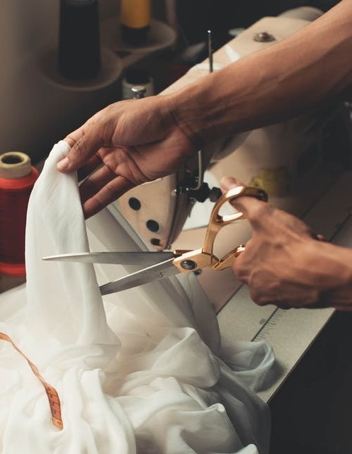A person cutting white fabric