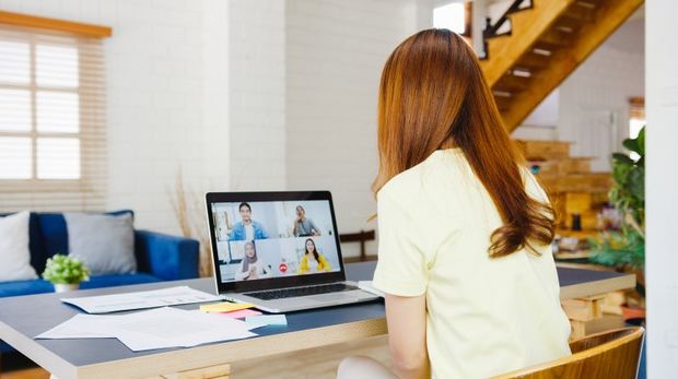 An image of a woman at a virtual meeting with her colleagues