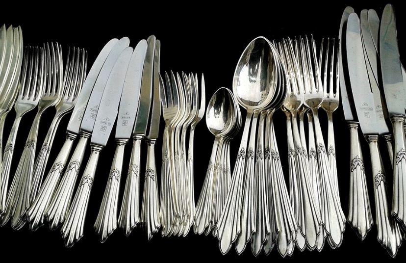 sets of silver forks, knives, and spoons