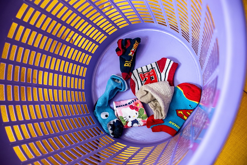 a violet laundry basket with children’s socks inside