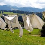 white hanging clothes, mountain, and trees background